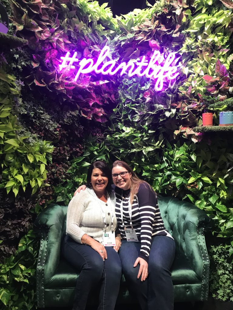 two friends posing up a hashtag plant life sign